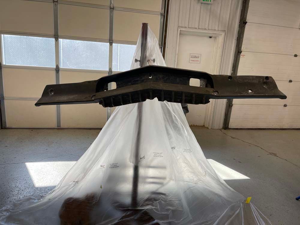 A piece of plastic is covering a piece of metal in a garage.