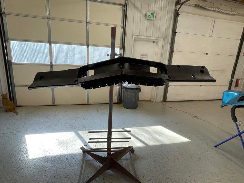 A piece of metal is sitting on top of a metal stand in a garage.