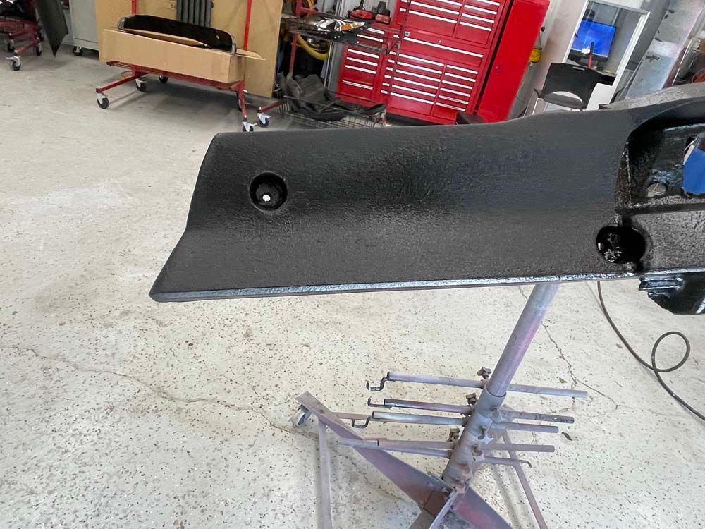 A piece of black plastic is sitting on a metal stand in a garage.