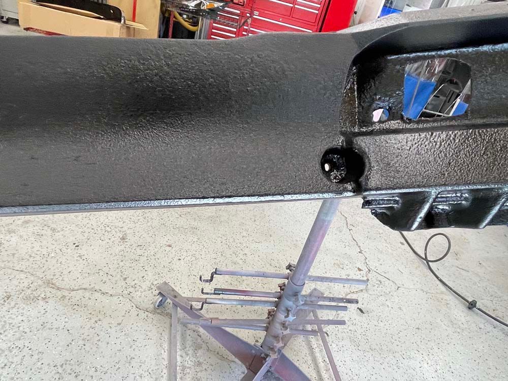 A black piece of metal is sitting on top of a metal stand.