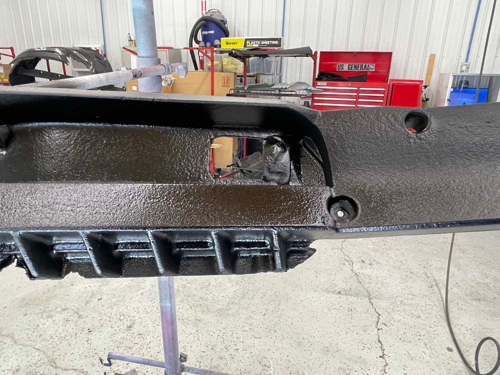 A piece of metal is sitting on a stand in a garage.