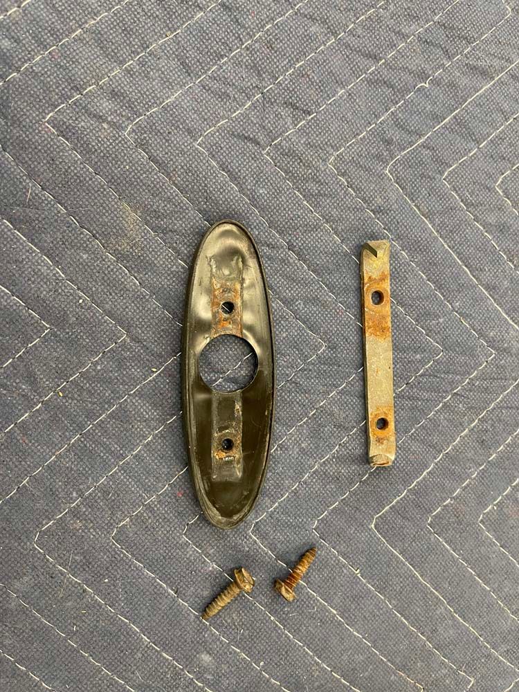 A piece of metal is sitting on top of a gray blanket on a table.