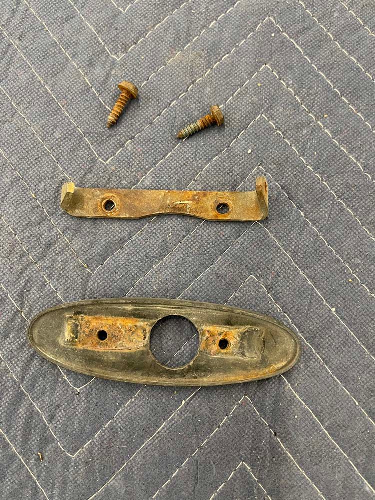 A piece of rusty metal is sitting on top of a gray blanket.