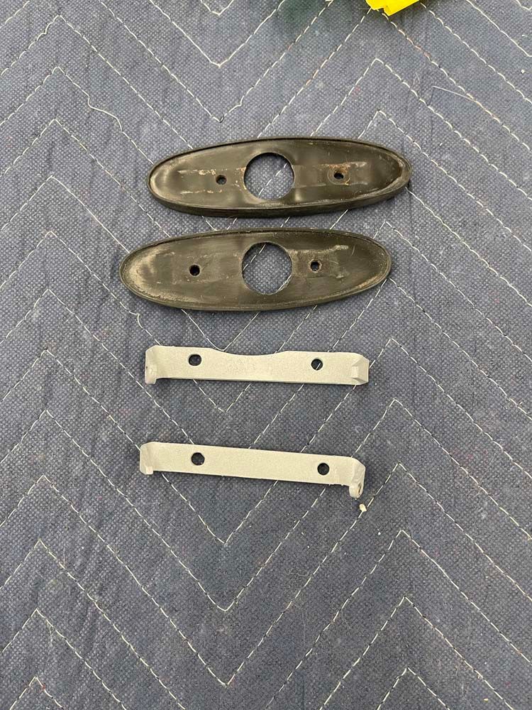 A pair of door handles are sitting on top of a blanket on a table.