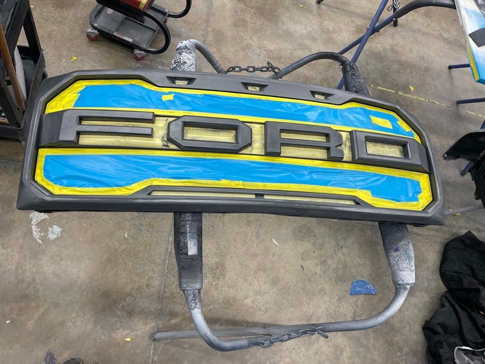 A blue and yellow ford logo is sitting on a table.
