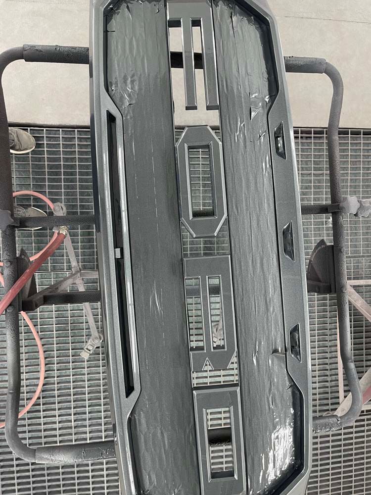 A black grille is sitting on top of a metal grid.