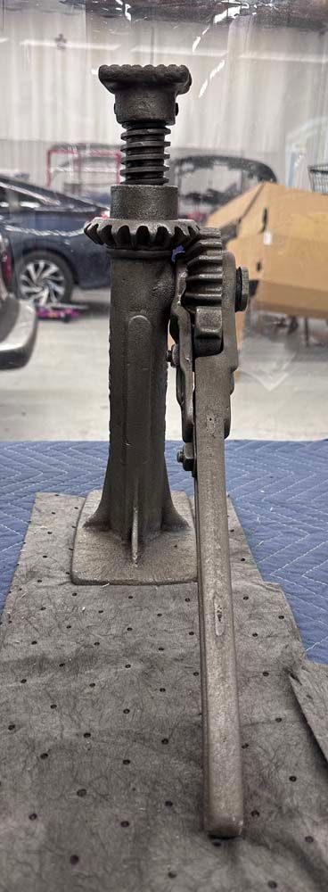 A car jack is sitting on top of a table in a garage.