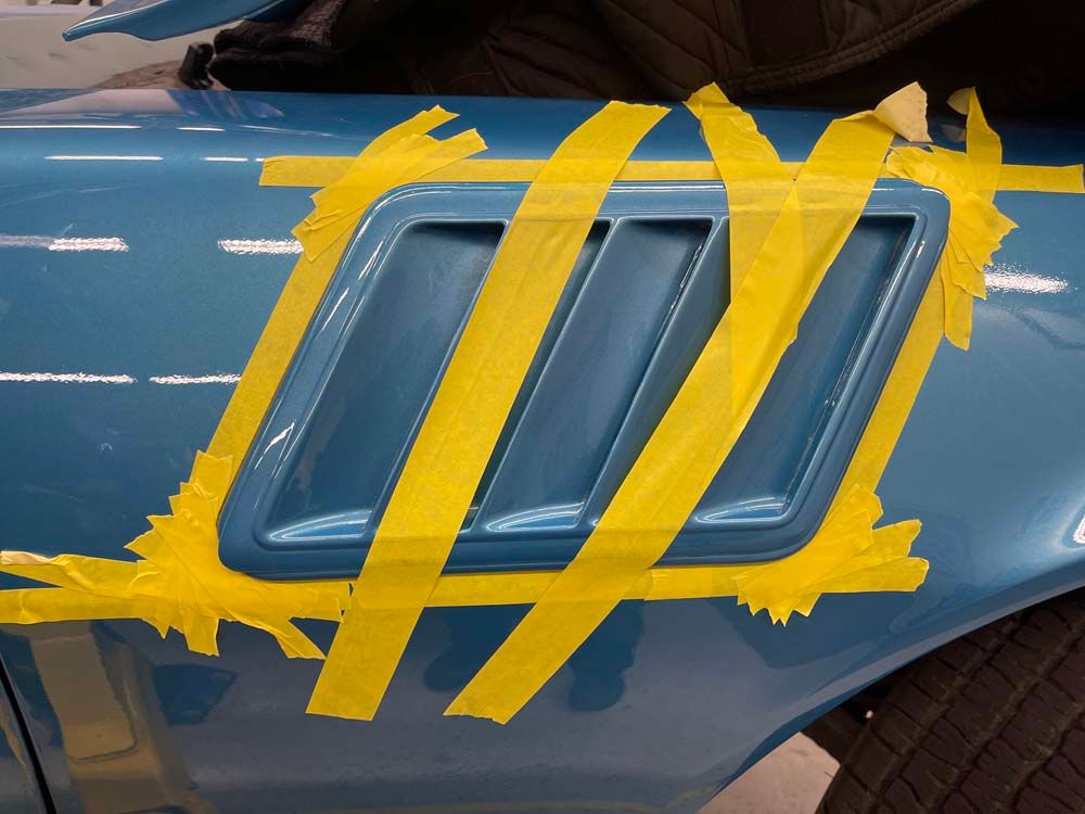 A blue car with yellow tape on it