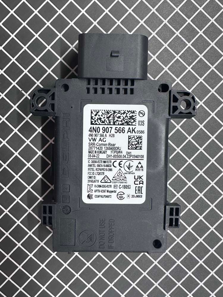 A black electronic device is sitting on top of a checkered table.