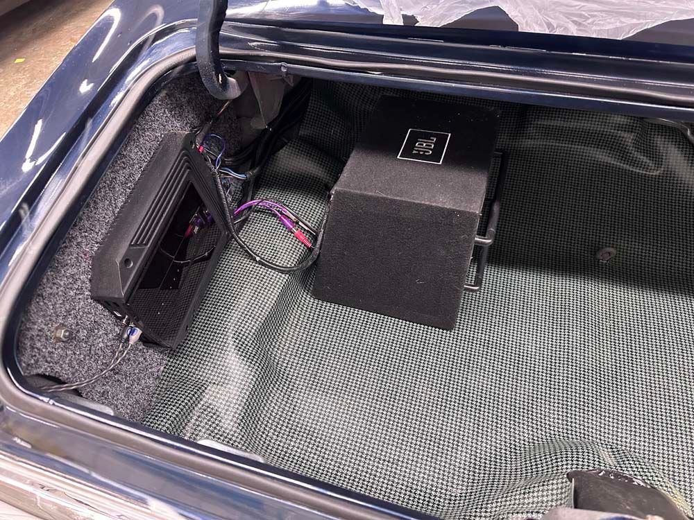 The trunk of a car with a speaker in it.