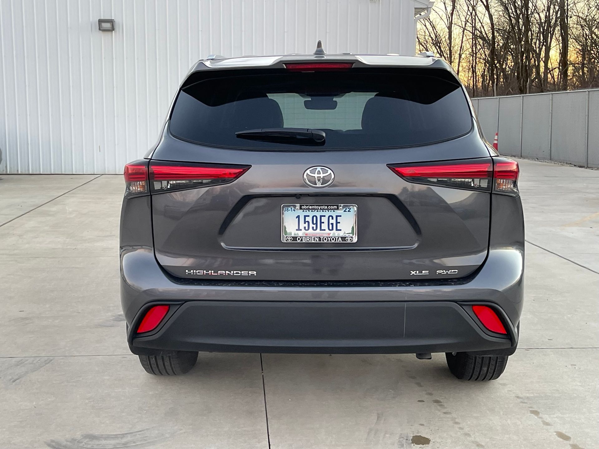 A gray toyota highlander is parked in a parking lot.