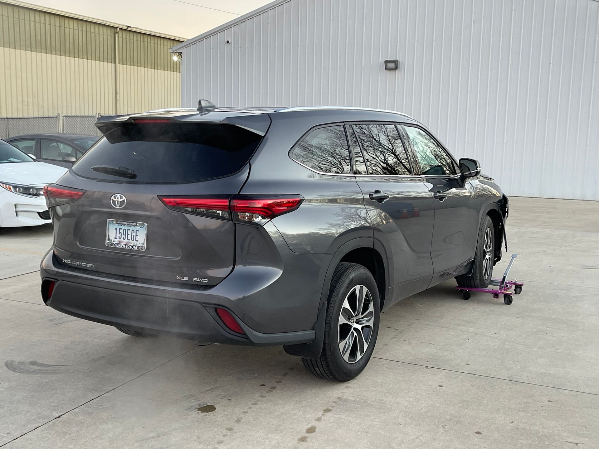 A toyota highlander is parked in a parking lot next to a building.