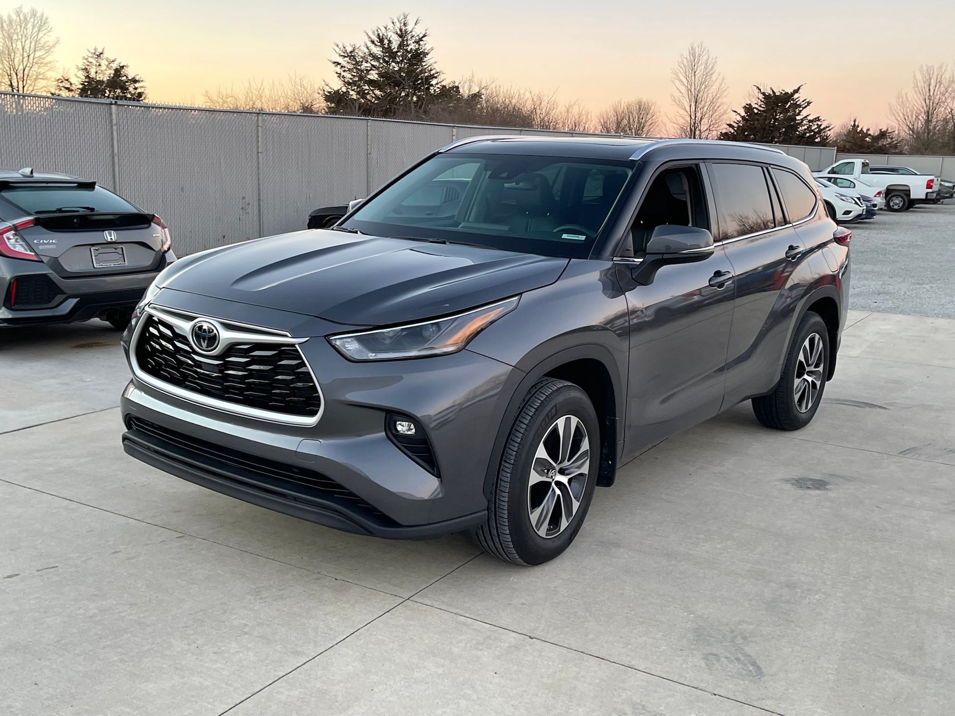 A gray toyota highlander is parked in a parking lot.
