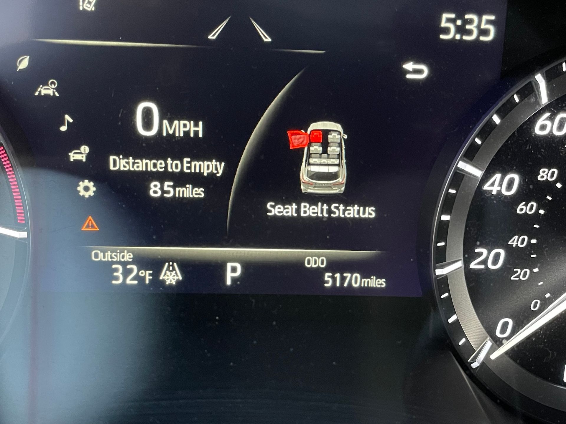 A close up of a car dashboard showing the seat belt status