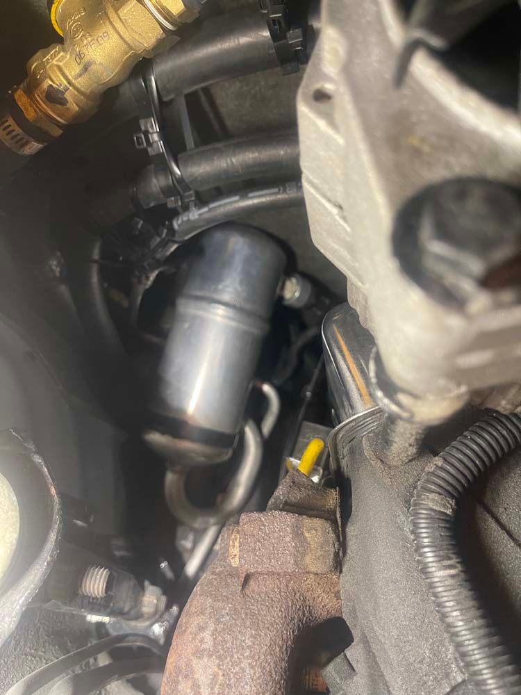 A close up of a metal pipe in a car engine.