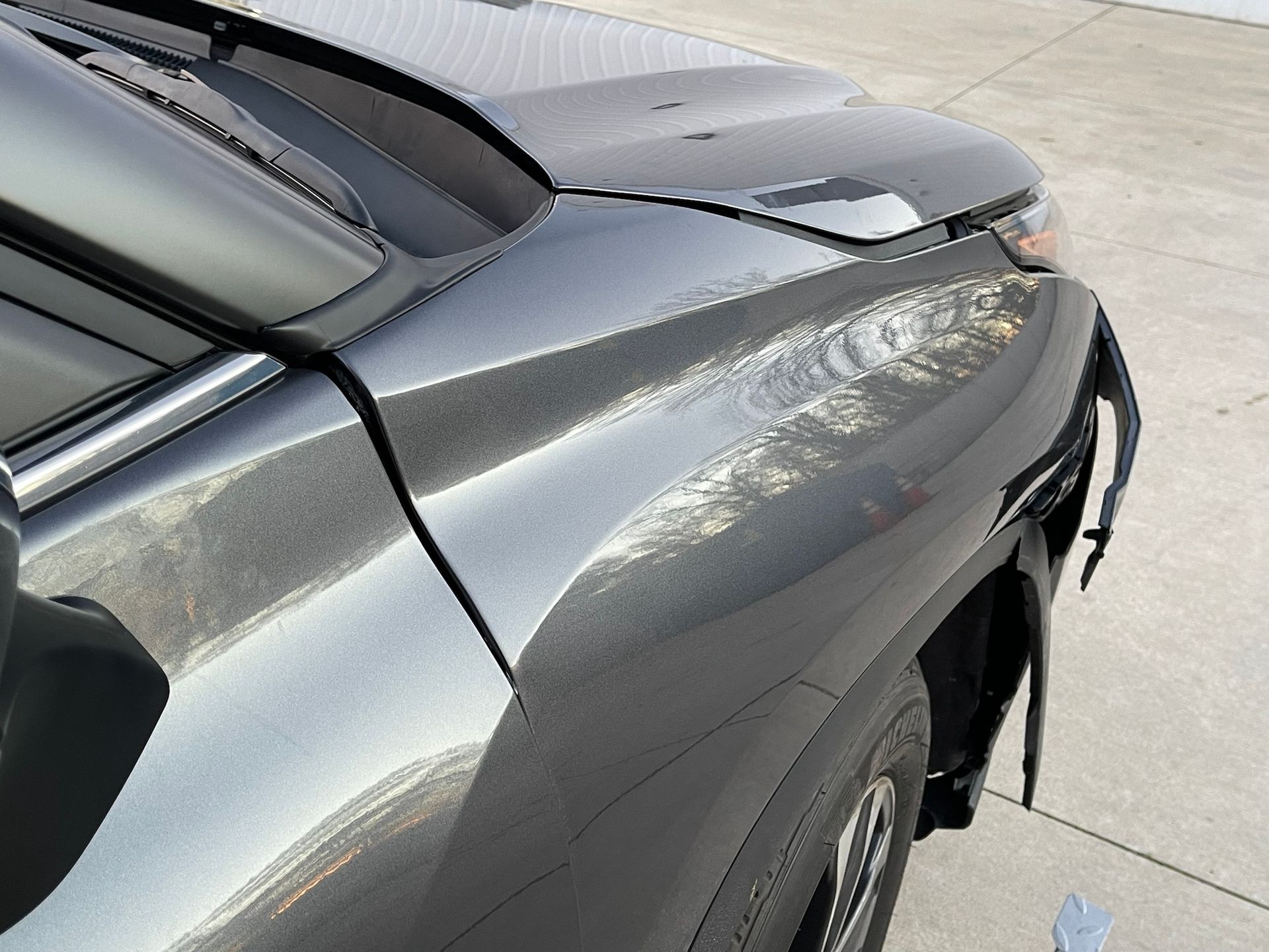 A close up of a car with a damaged fender