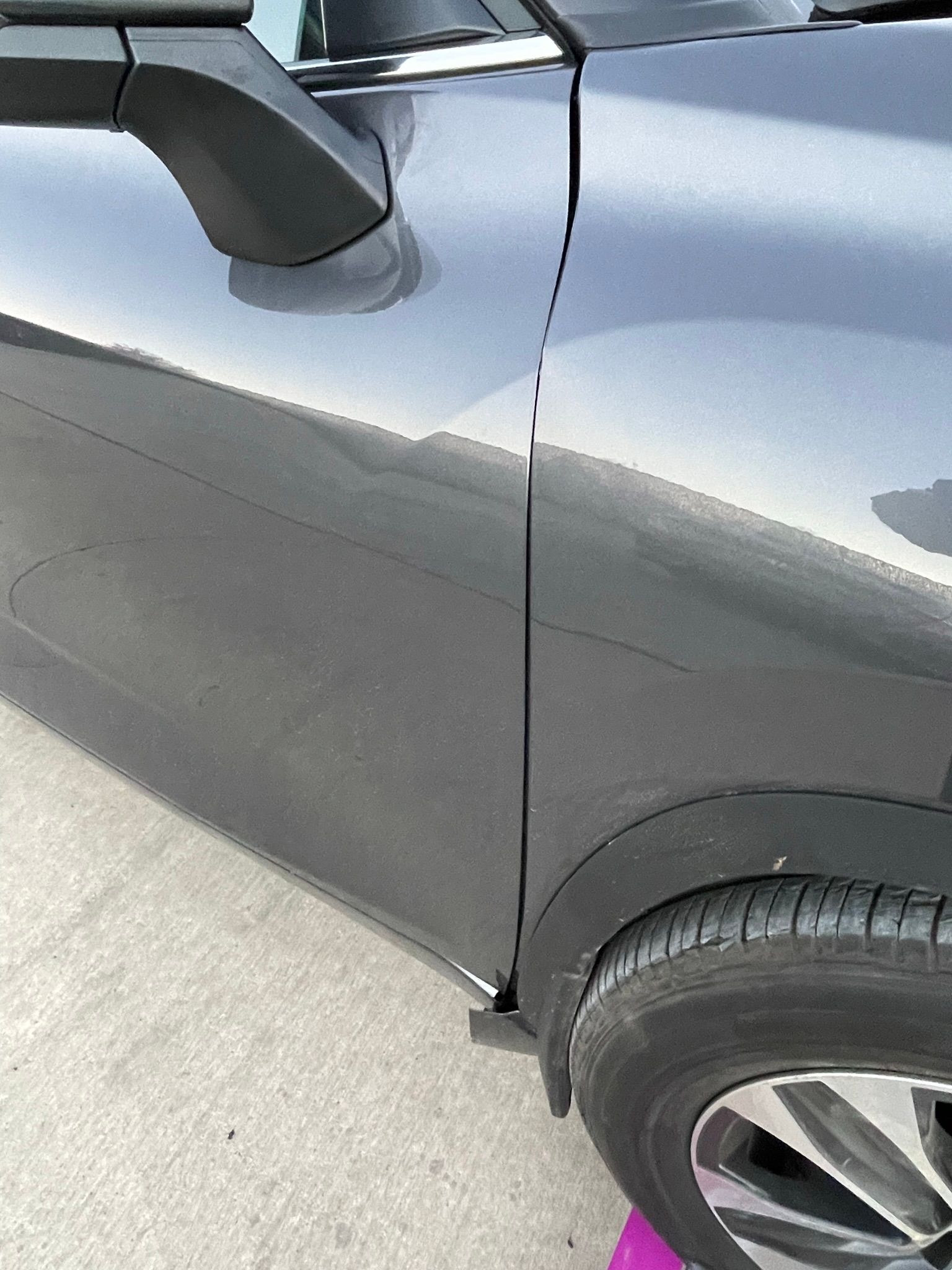 A black car is parked on the side of the road.