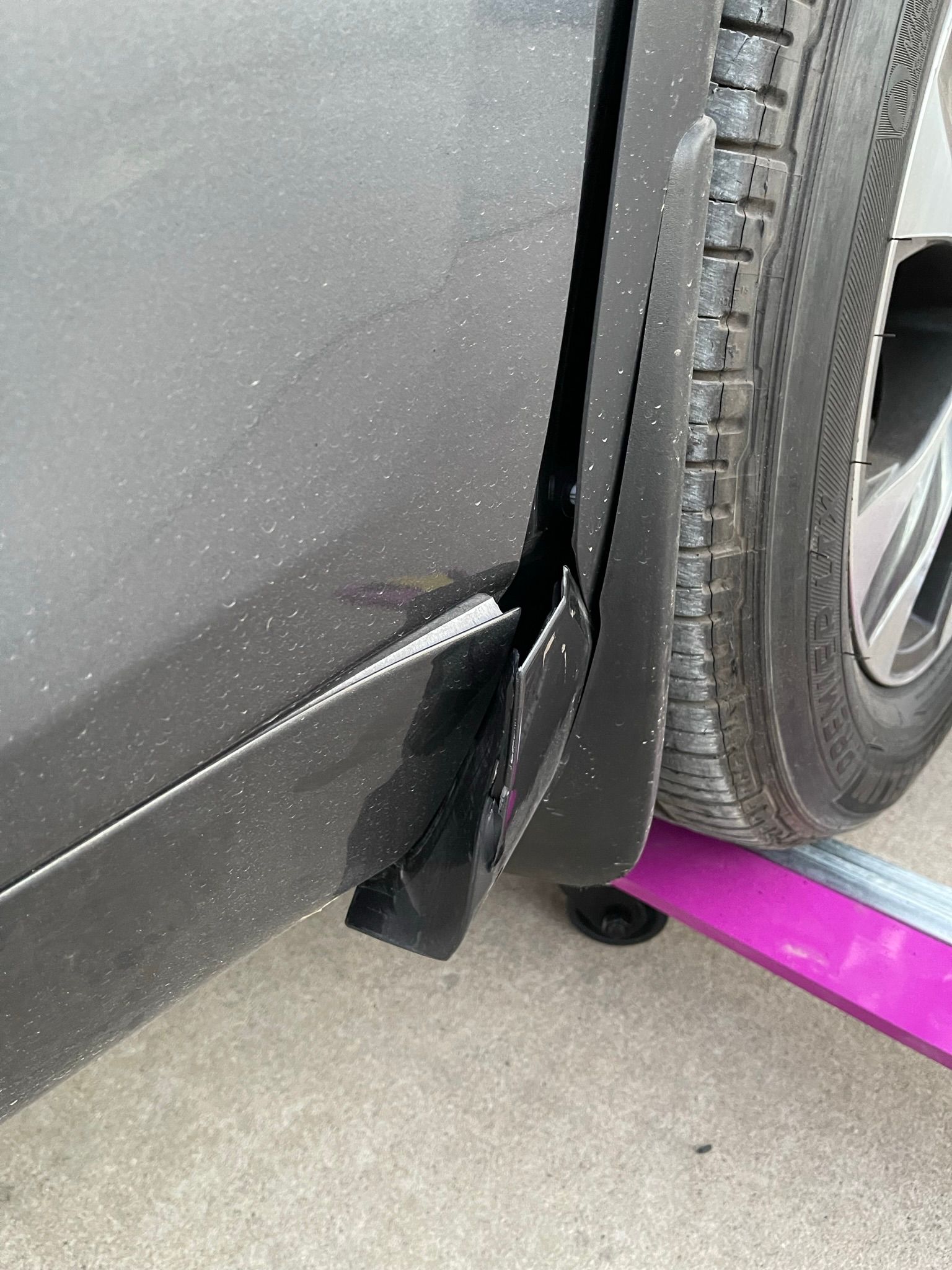 A close up of a car with a damaged tire and fender.