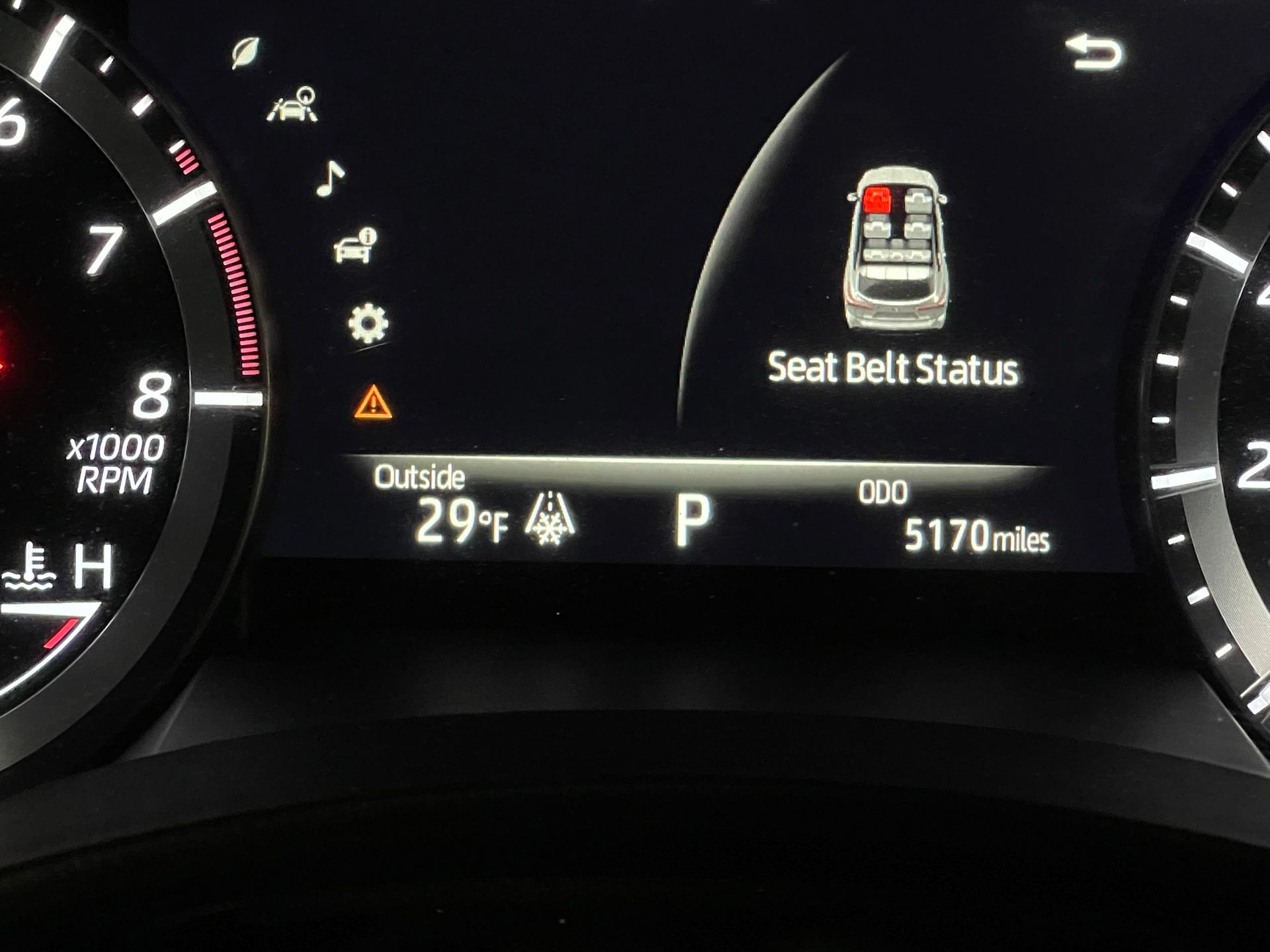 A close up of a car dashboard showing the seat belt status