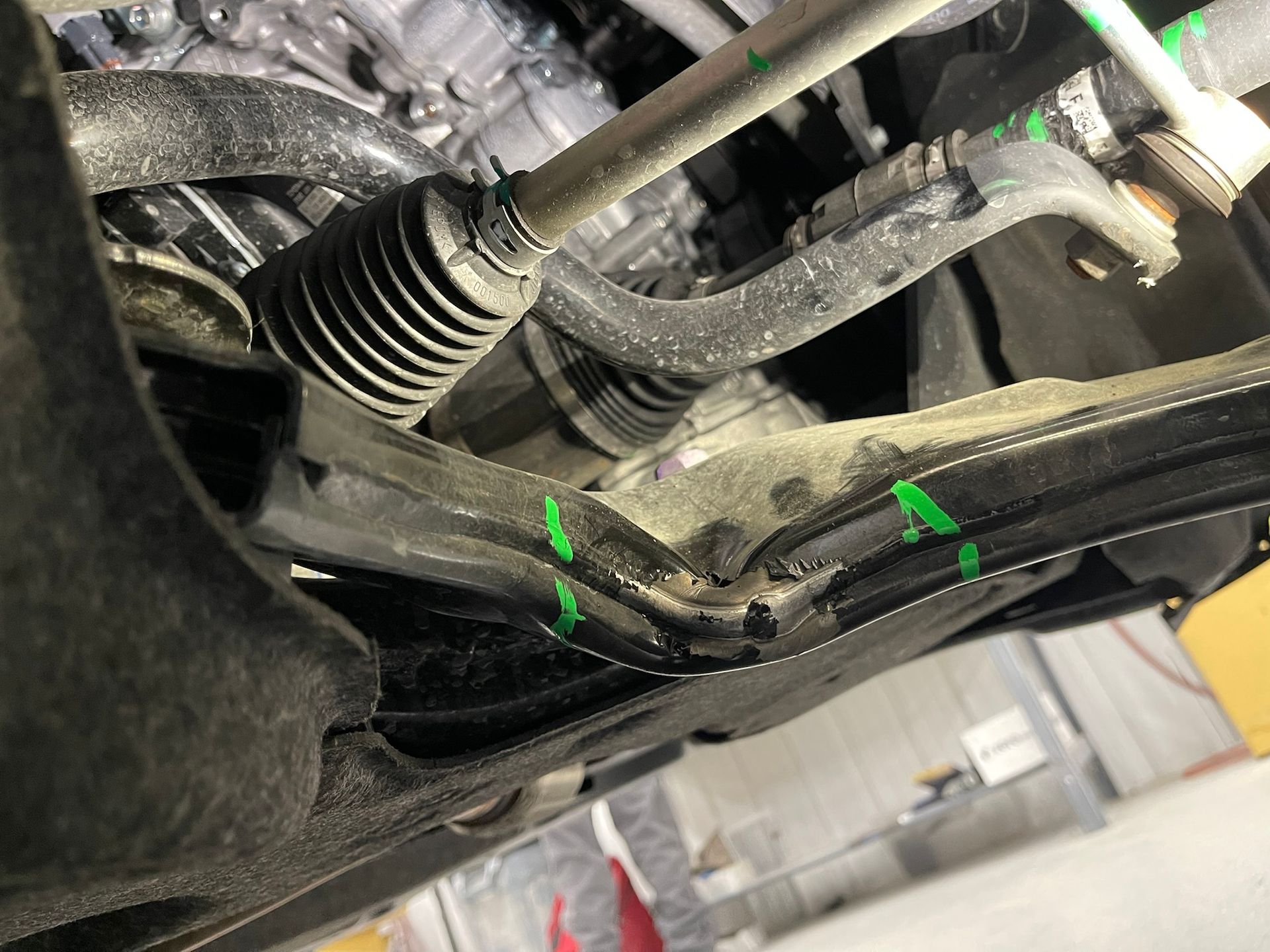 A close up of the underside of a car with green markings on it.