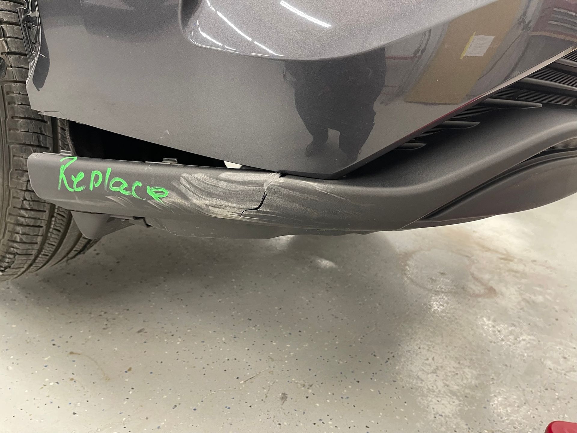 The bumper of a car is damaged and needs to be replaced.