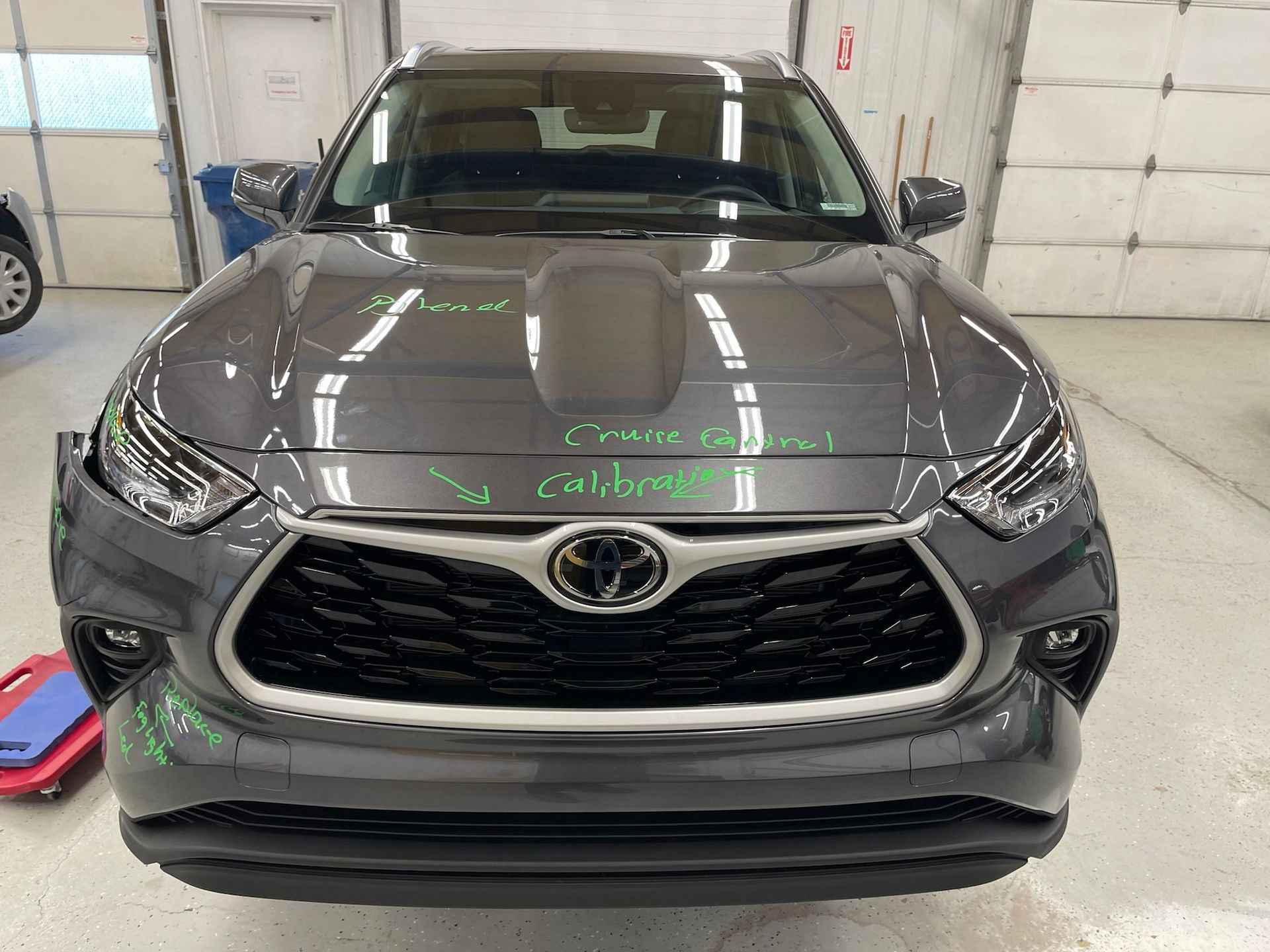 A gray toyota highlander is parked in a garage.
