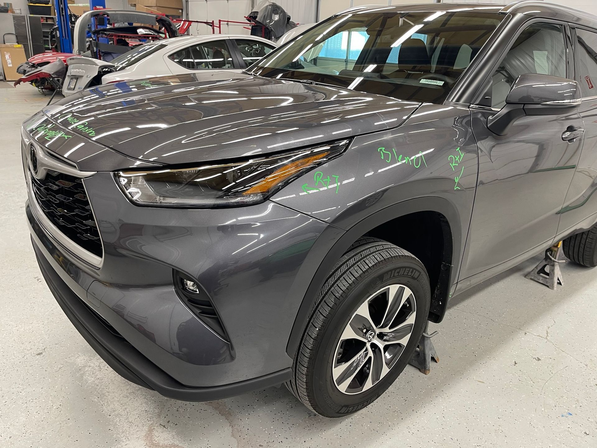 A gray toyota highlander is parked in a garage.