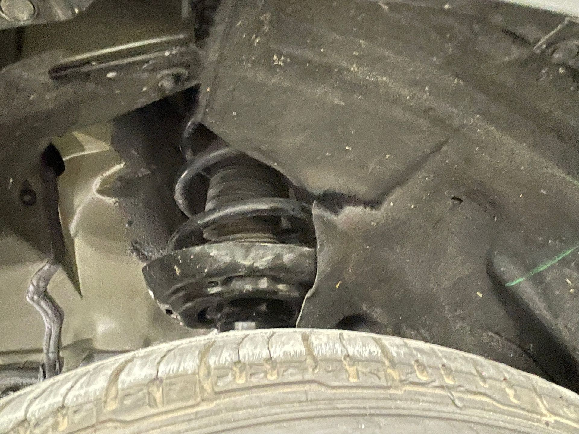 A close up of a car shock absorber and tire
