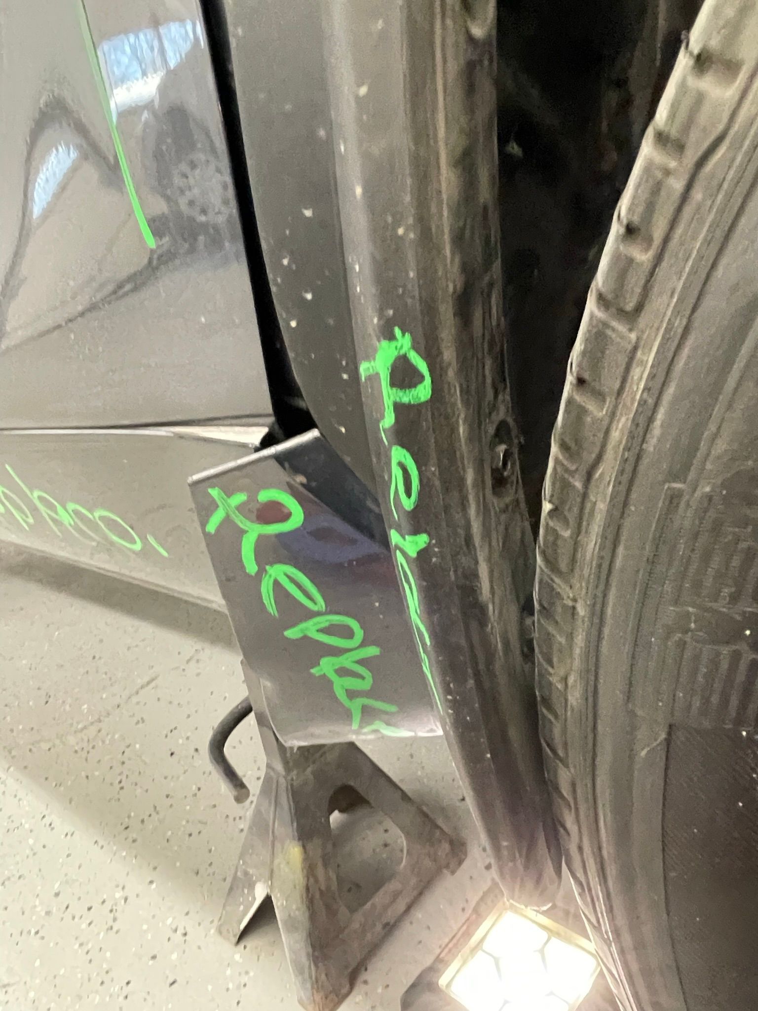 A car is sitting on a jack in a garage.