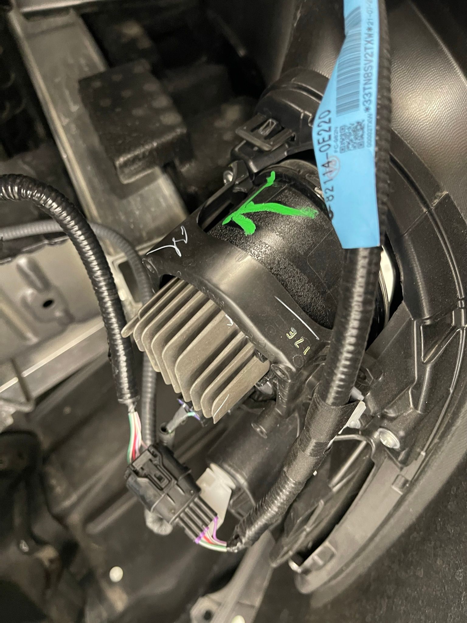 A close up of a car headlight with a blue tape on it.