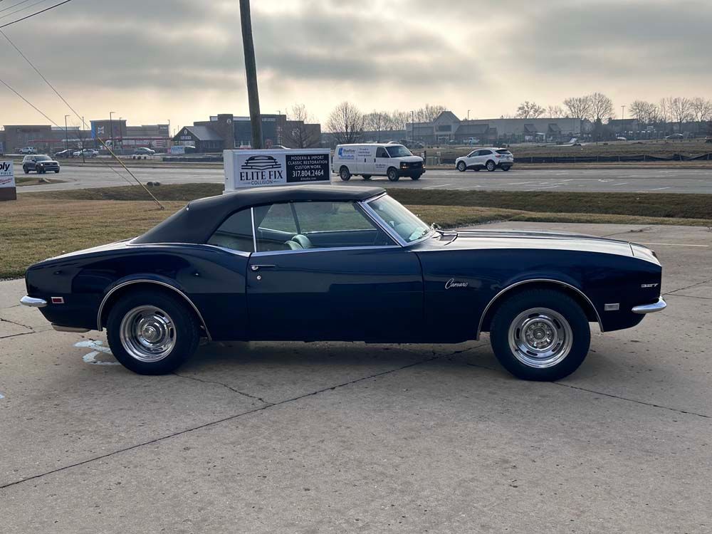 A blue car is parked on the side of the road.