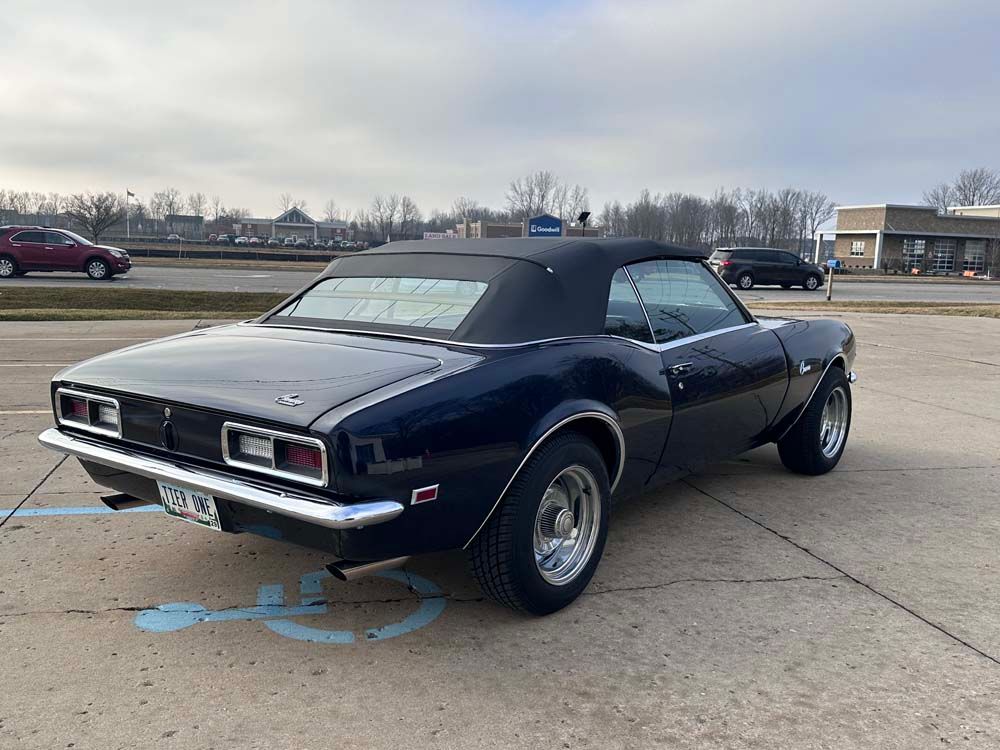 A black car is parked in a handicapped parking spot.