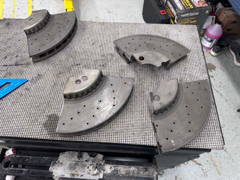 A bunch of brake rotors are sitting on a table.