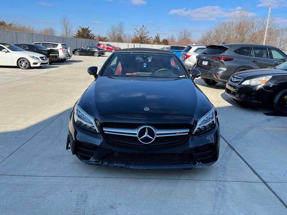 A black mercedes c class is parked in a parking lot.