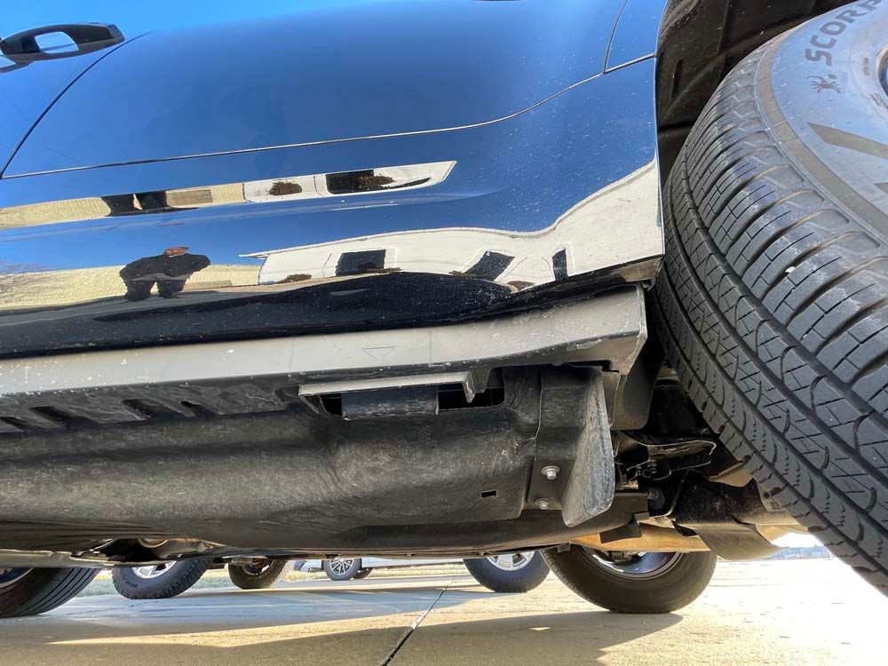 A blue car is parked next to a black tire.