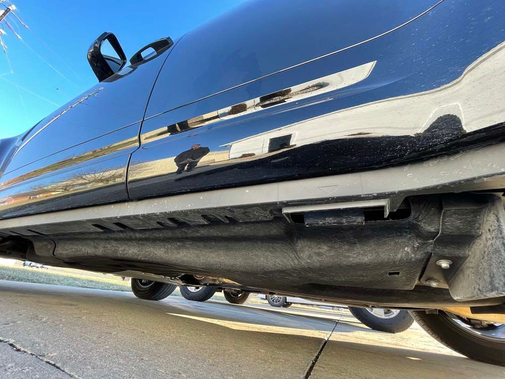 A black car is parked on the side of the road.