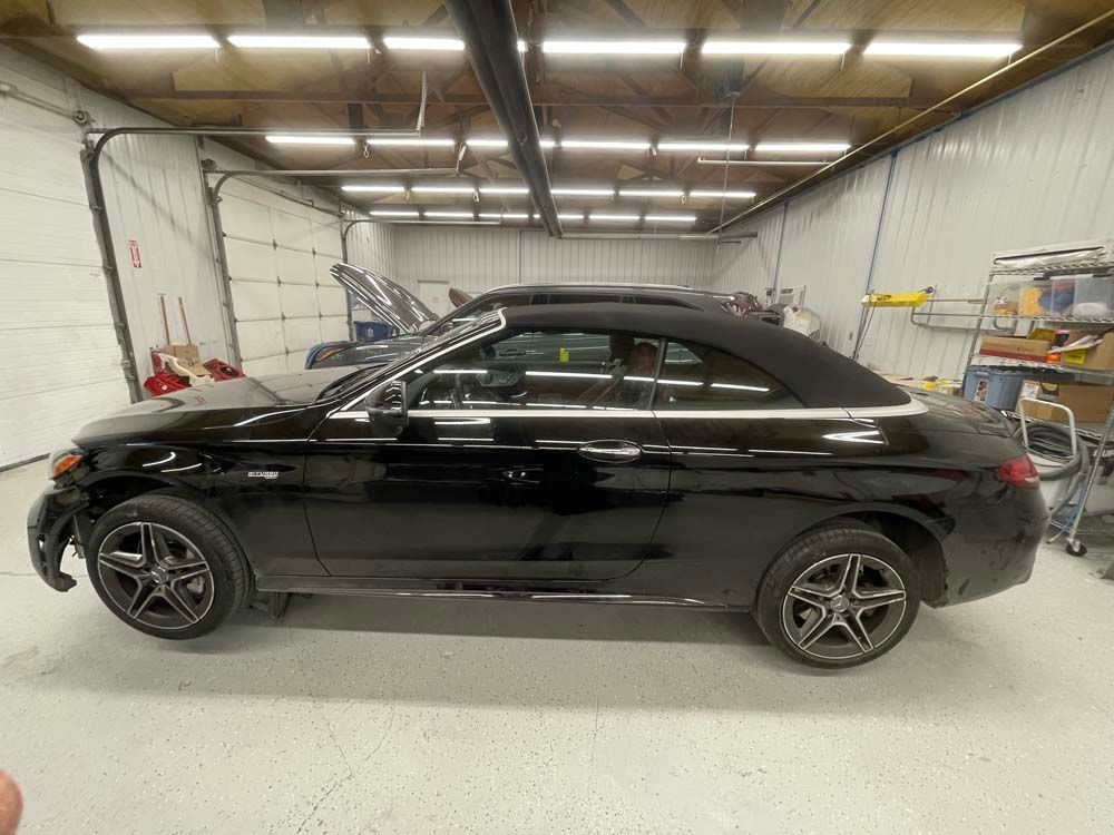 A black convertible is parked in a garage.