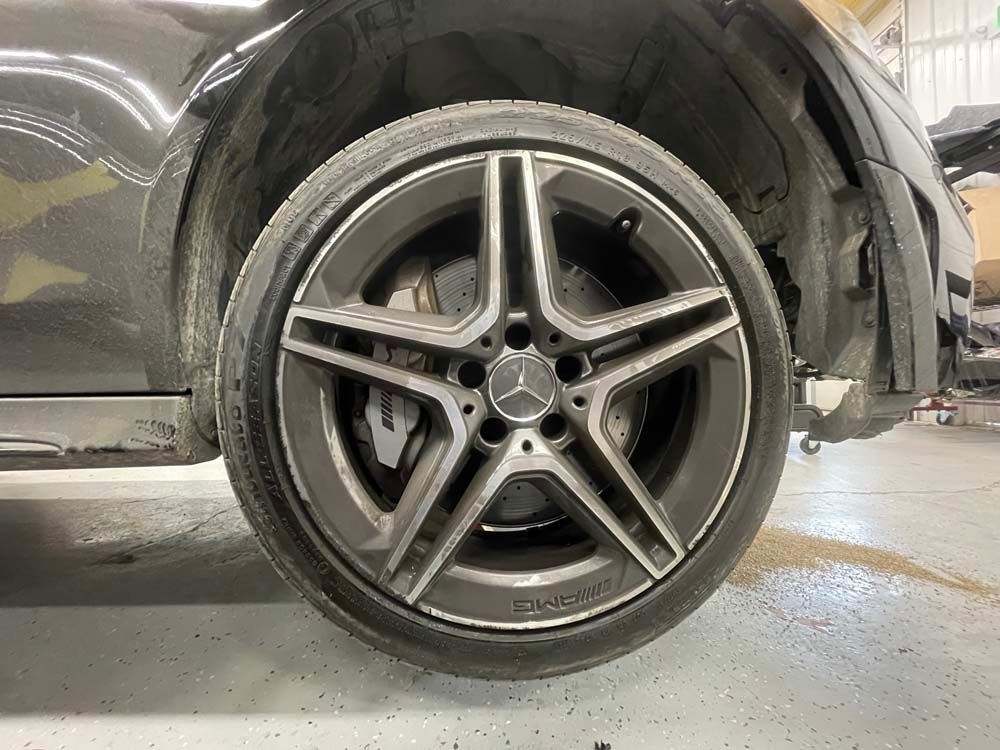 A close up of a car wheel in a garage.
