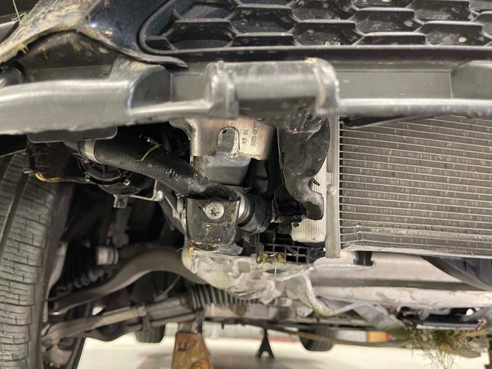 A close up of the underside of a car with a radiator.