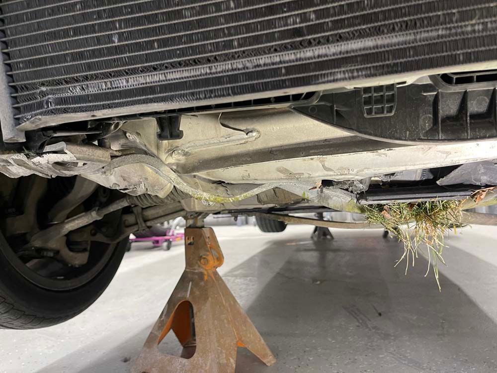 A car is sitting on a jack stand in a garage.