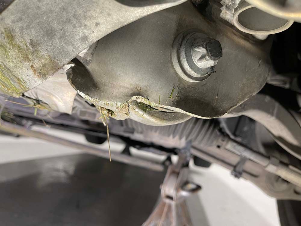 A close up of the underside of a car with water coming out of it.