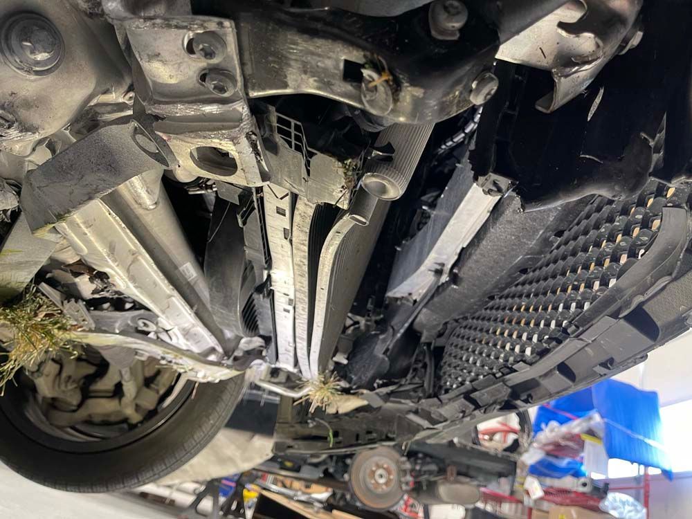 A close up of the underside of a car in a garage.
