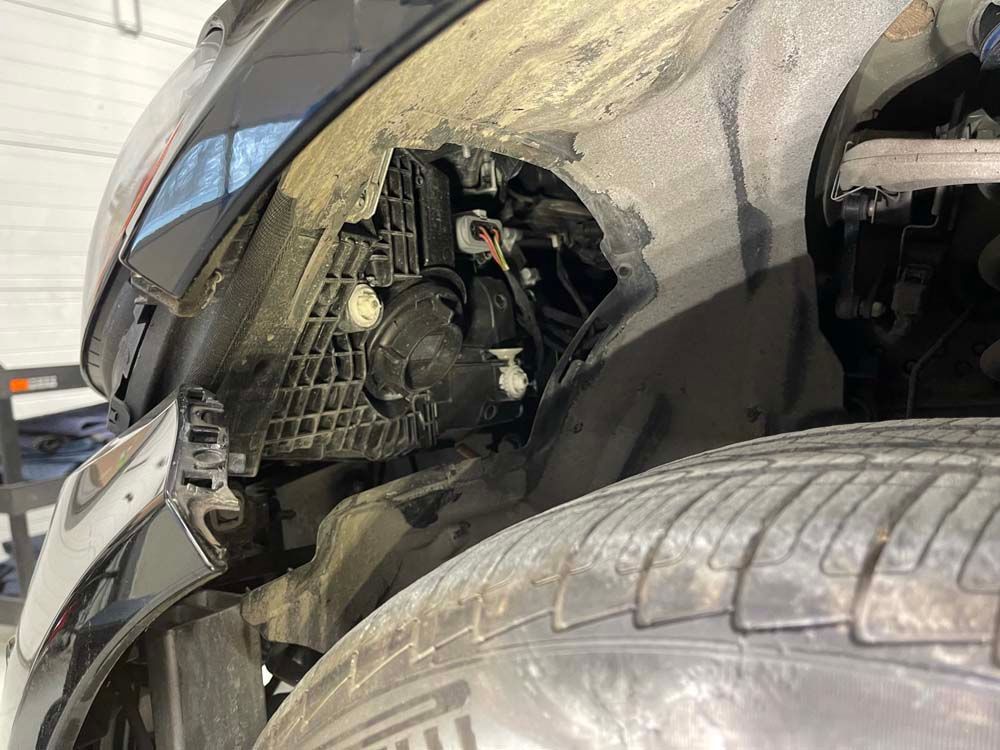 A close up of a car 's headlight and tire.