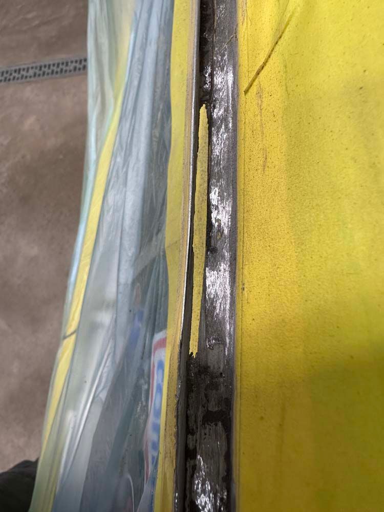 A close up of a piece of metal on a yellow surface.