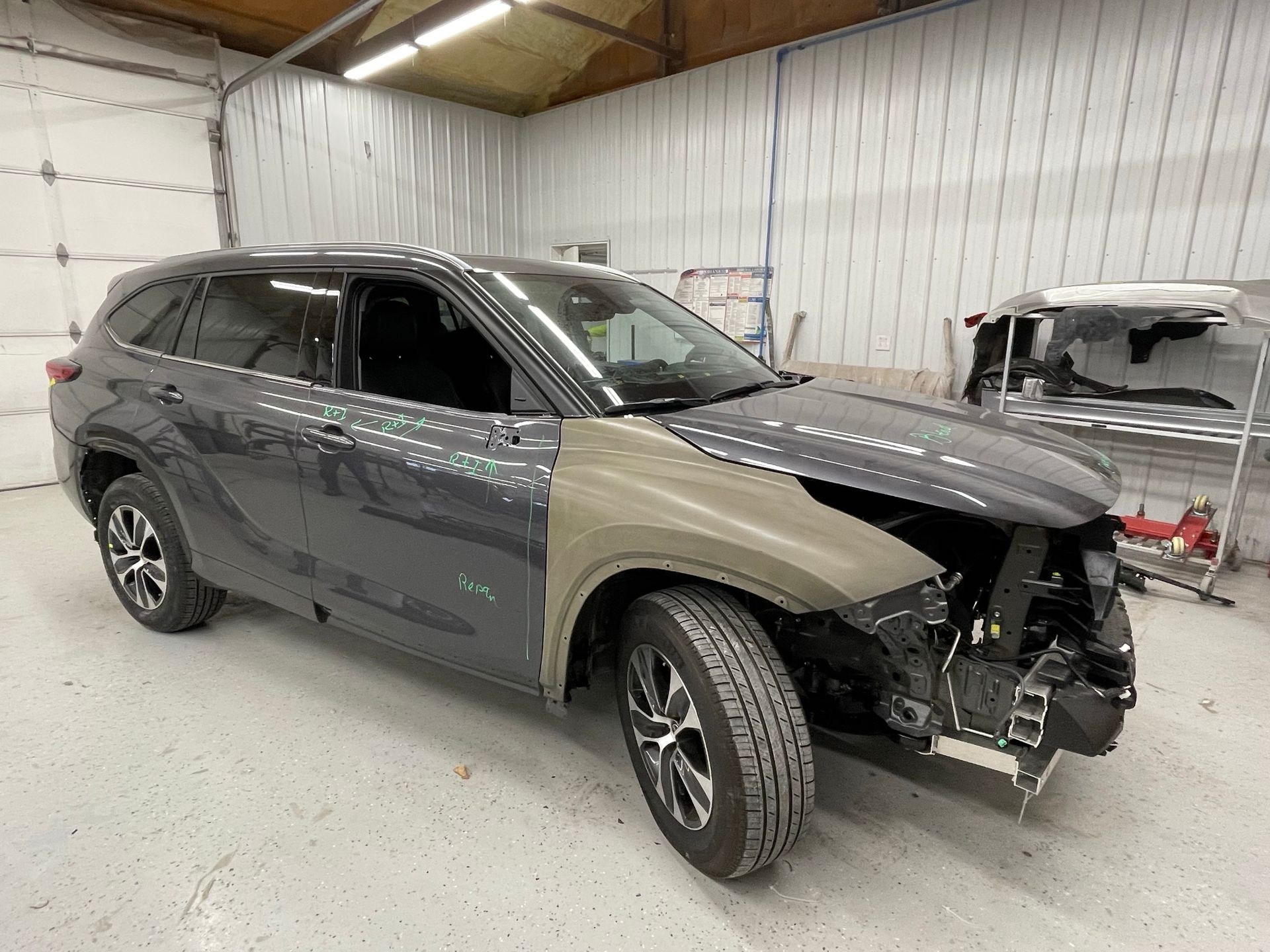 A car that has been damaged is sitting in a garage.
