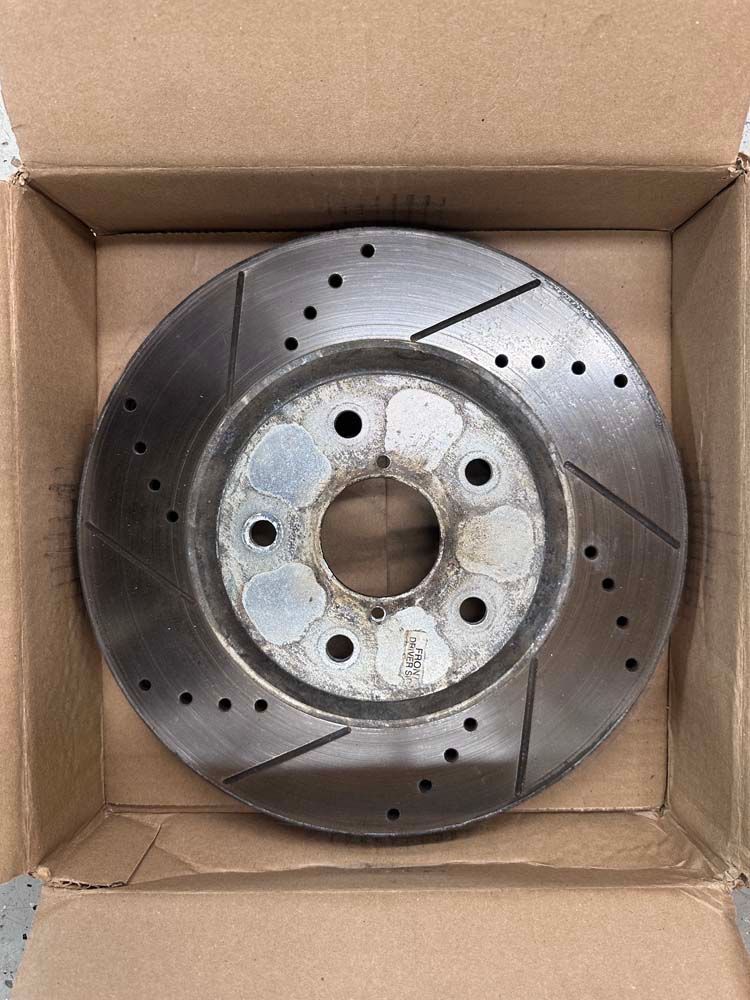 A close up of a brake disc in a box.