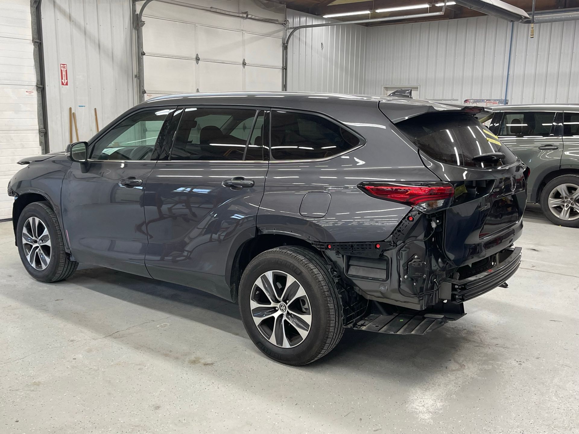 A gray toyota highlander is parked in a garage.