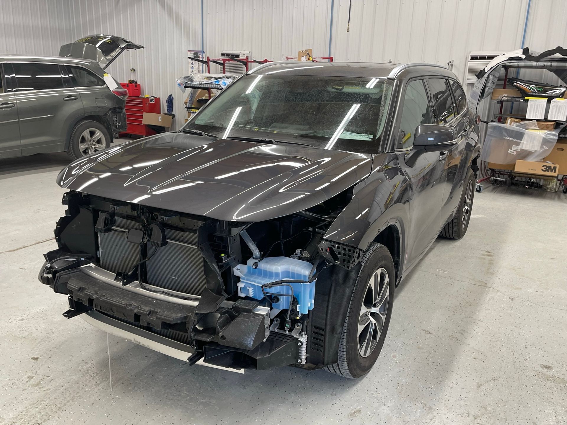 A damaged car is sitting in a garage.