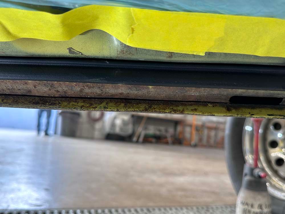A close up of the underside of a car with yellow tape on it.