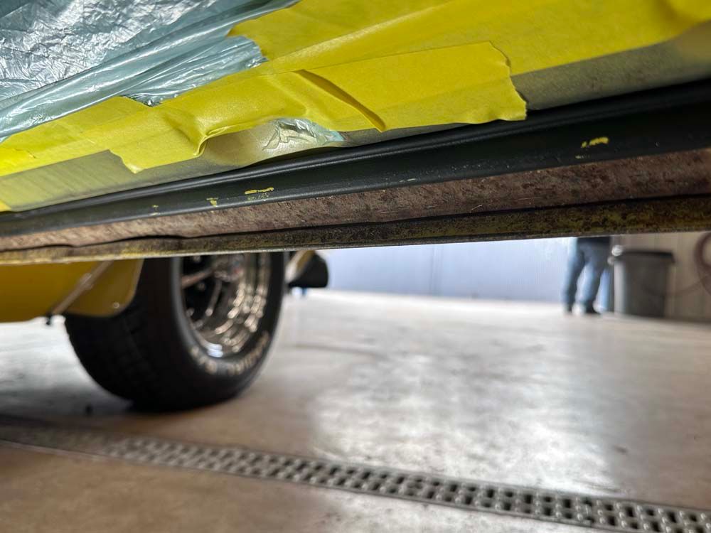 A yellow tape is covering the underside of a car.
